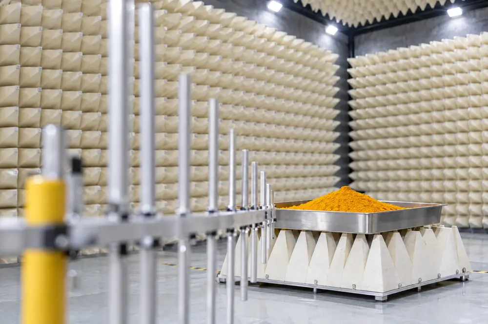 Illustration: a tray of turmeric extract on an absorber-lined platform, an antenna in front