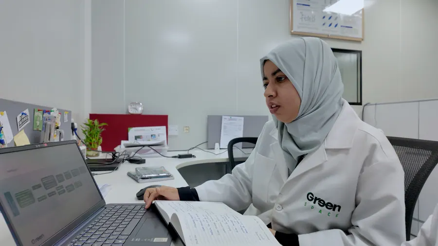 A scientist recording results at her laptop